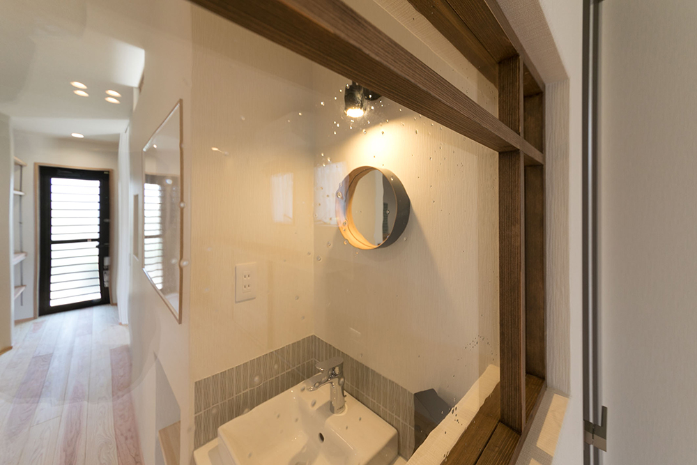 家族用玄関の近くには、気泡が入ったハンドクラフトガラスがあしらわれた手洗い場を設置