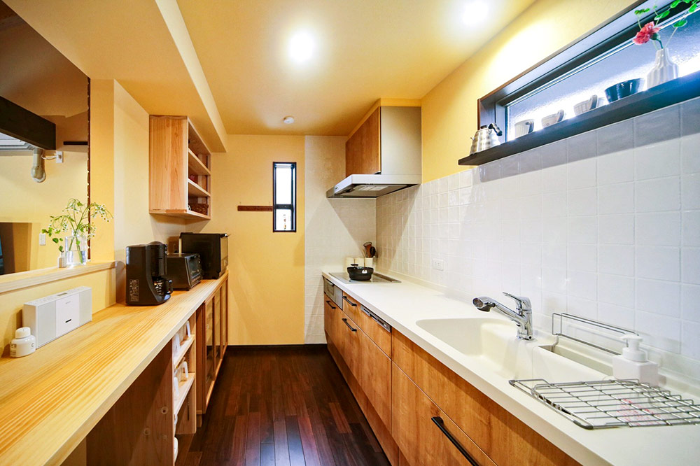 奥様こだわりの白いタイルは掃除がしやすく、使い勝手のよいカウンターとたっぷり収納も