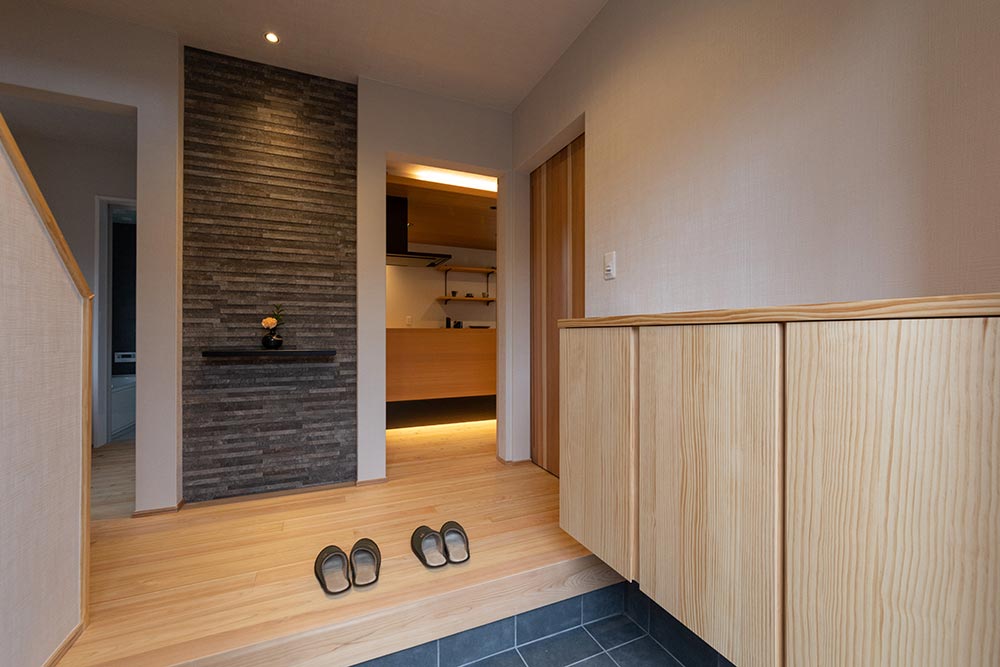 正面のアクセントウォールが、高級感を演出する玄関スペース