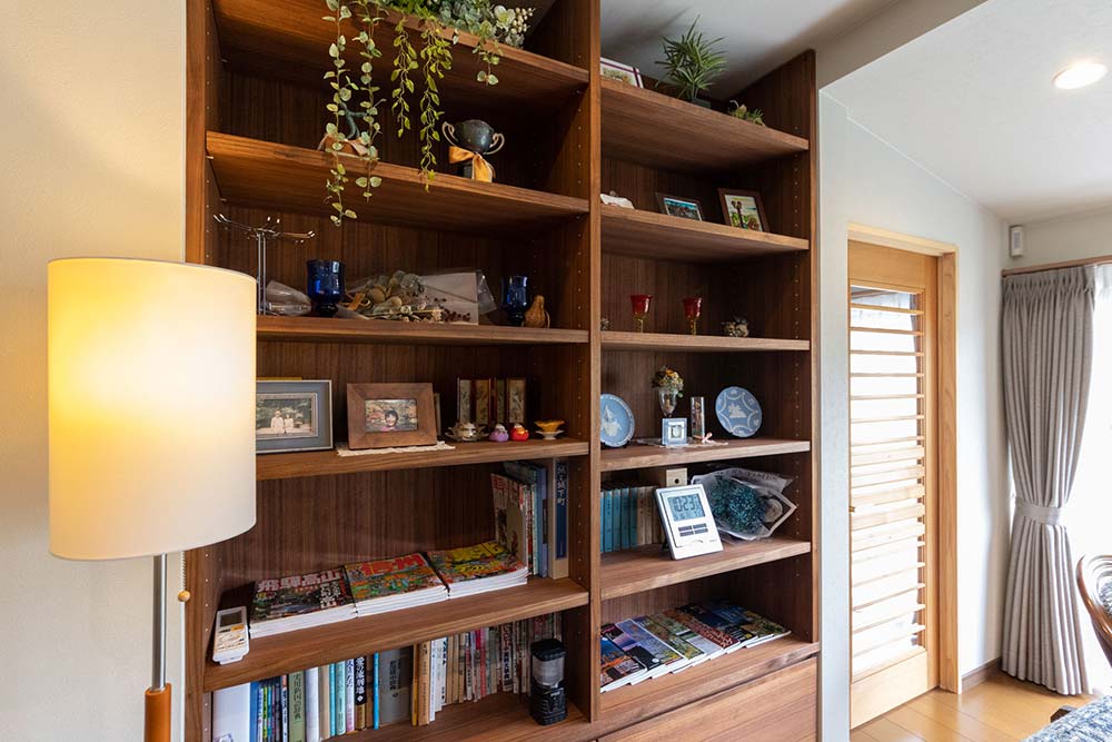 旅行の思い出の品や家族写真を飾られている、ウォールナット材の本棚
