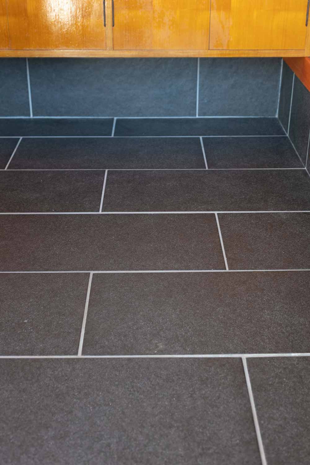 玄関の床は、空間にメリハリを生む濃いグレーのタイルに