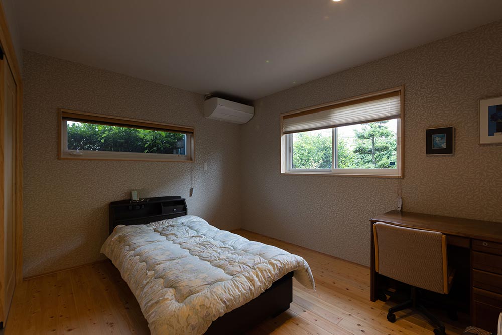 窓辺の緑に癒やされる、木の温もりに包まれた安らぎの寝室