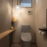 グレーのアクセントクロスと木のカウンターが織りなす、上質な落ち着き感のあるトイレ